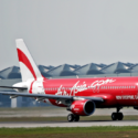 a red and white airplane on a runway