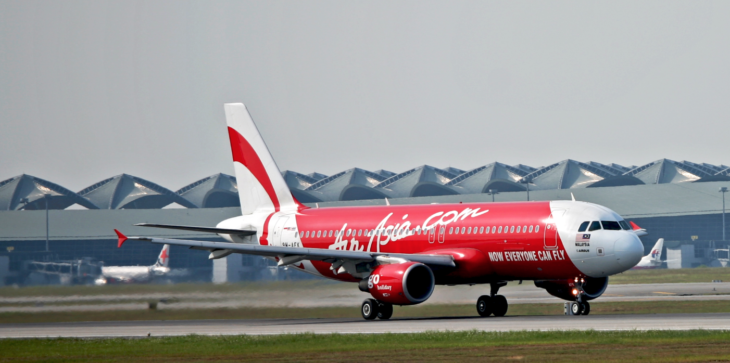 a red and white airplane on a runway