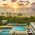 a pool and palm trees on a beach