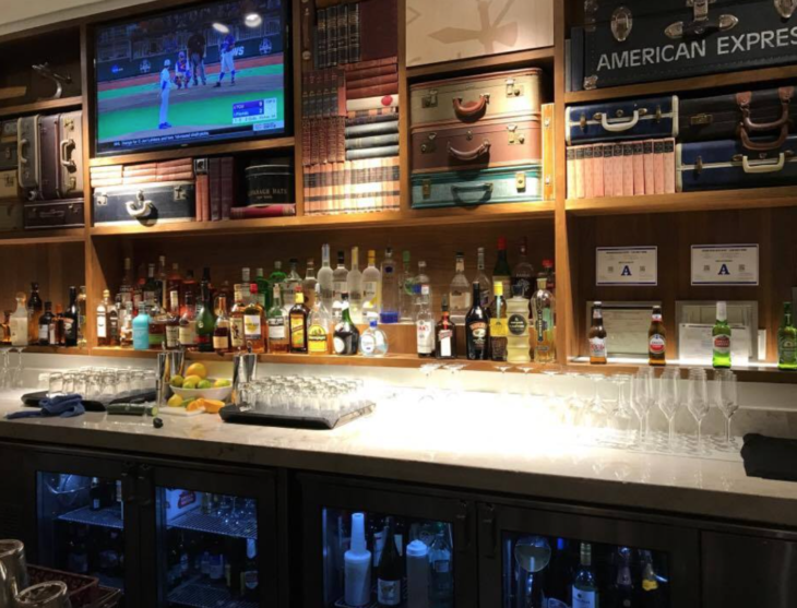 a bar with shelves of liquor and televisions