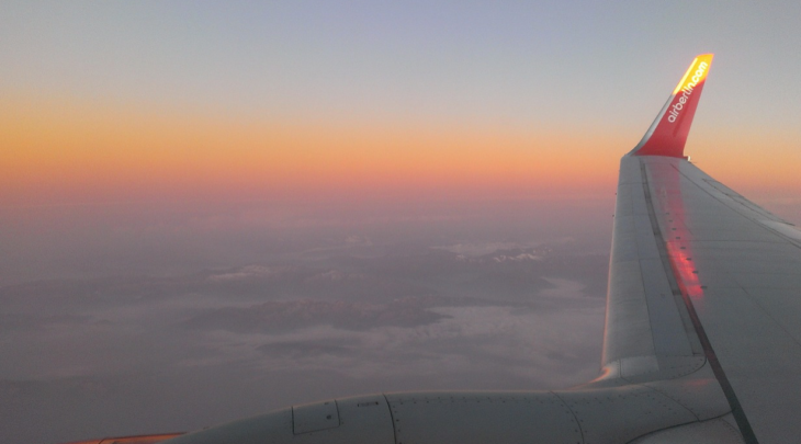 an airplane wing with a sunset in the background