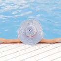 a person wearing a hat leaning on a pool edge