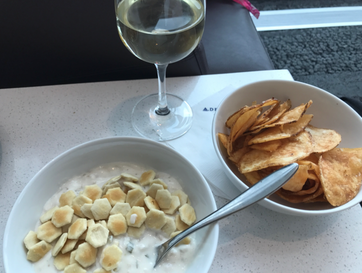 a bowl of food and a glass of wine