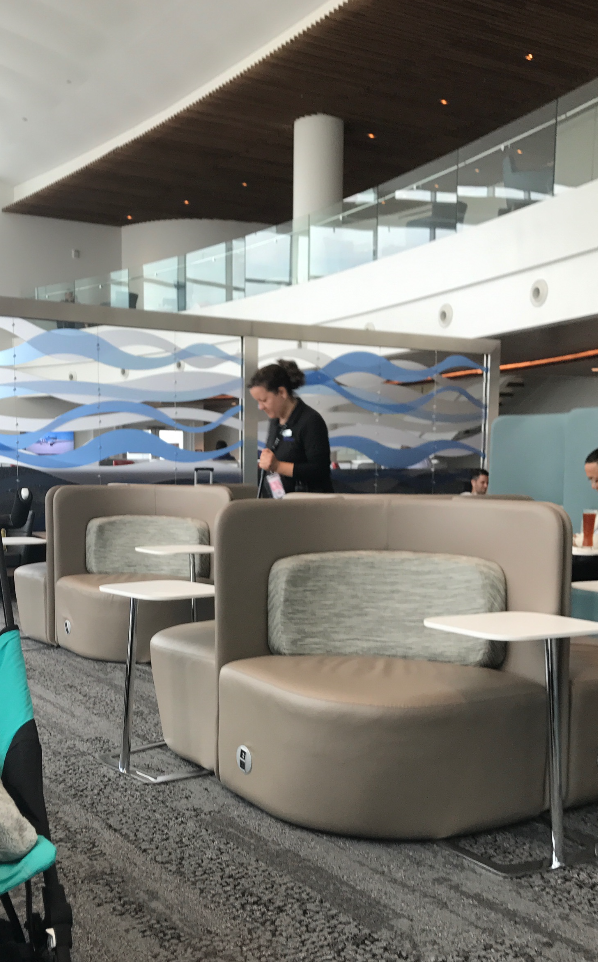 a woman standing in a room with chairs and tables