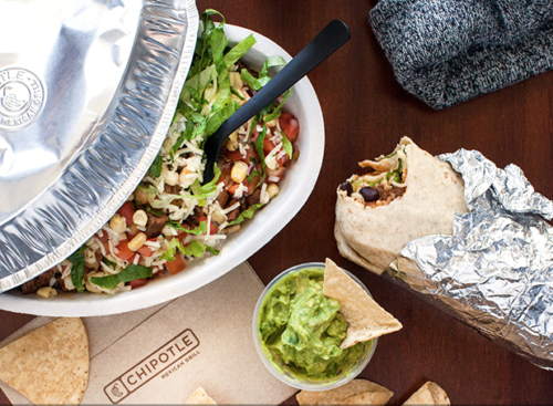 a bowl of salad and burrito next to a burrito