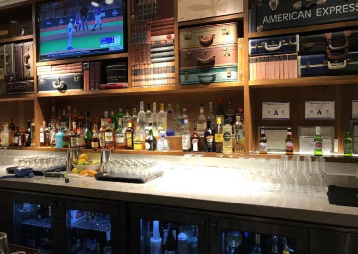 a bar with shelves of liquor and televisions
