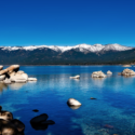 a body of water with rocks and mountains in the background