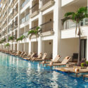 a pool with lounge chairs and palm trees