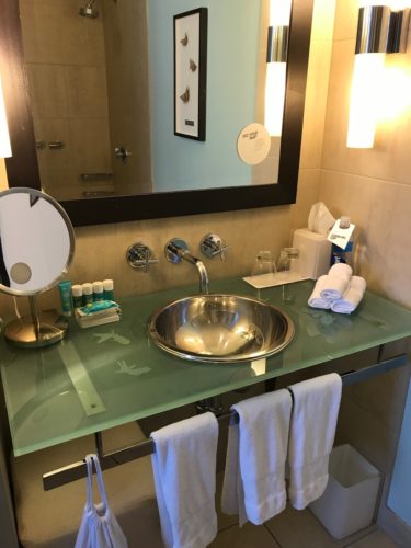 a bathroom sink with a mirror and towels