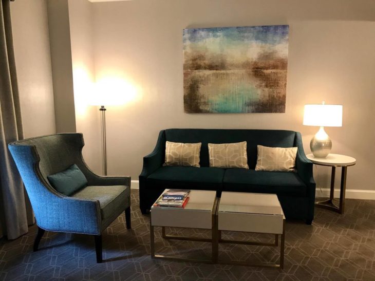 a room with a couch and a painting on the wall