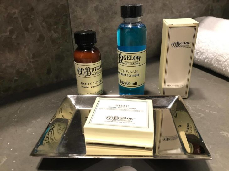 a silver tray with soap and bottles of liquid on it