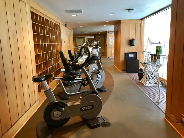 a room with exercise bikes and a glass shelf