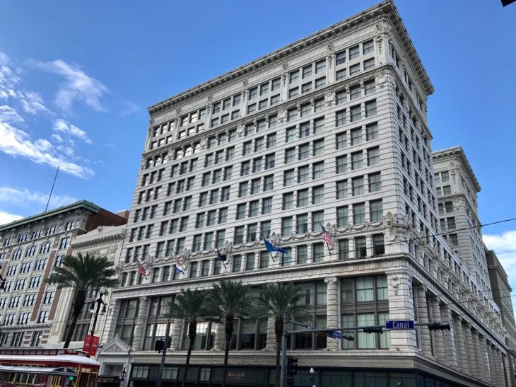 a building with palm trees and blue sky