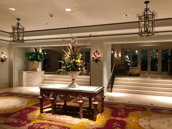 a large vase of flowers on a table in a room with stairs