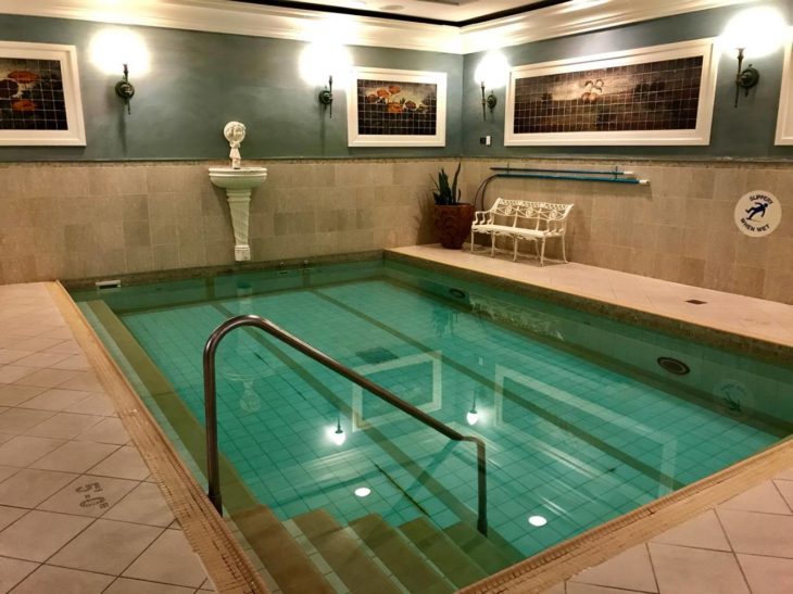 a indoor pool with a bench and a statue