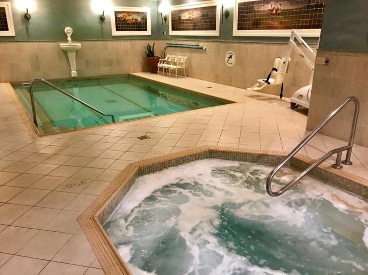 a indoor pool with a hot tub and a ladder