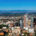 a city with many tall buildings and mountains in the background