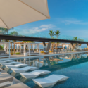 a pool with white chairs and umbrellas