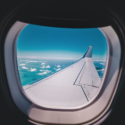 an airplane wing with clouds and blue sky