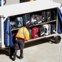 a man standing next to a cart full of luggage