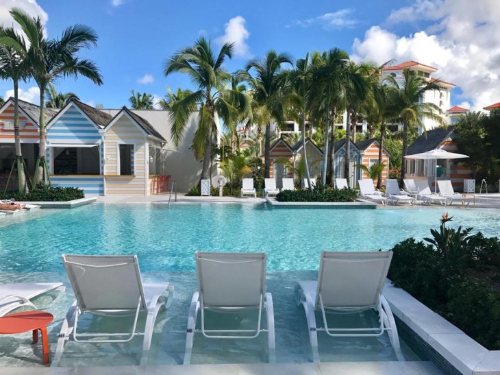 a pool with lounge chairs and palm trees