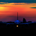 an airplane on the runway at sunset