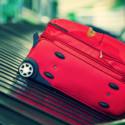 a red suitcase on a conveyor belt