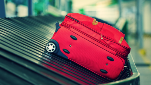 a red suitcase on a conveyor belt