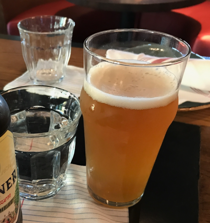 a glass of beer and a bottle of beer on a table