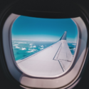 an airplane wing with clouds and blue sky