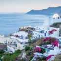 a white buildings on a hill overlooking a body of water