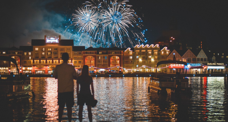 a man and woman looking at fireworks in the sky