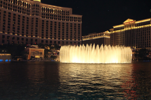 a water fountain with lights in front of Bellagio