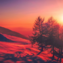 a sunset over a snowy mountain