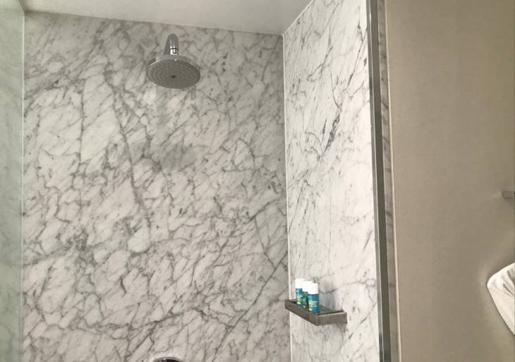 a shower with a marble wall