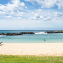 a beach with people swimming in the water