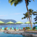 a pool with umbrellas and chairs by the water