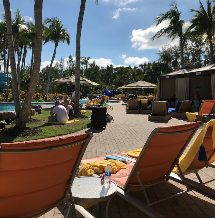 a group of people sitting on a pool side chairs