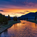 a river with trees and mountains in the background