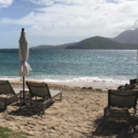 chairs on a beach with a large body of water