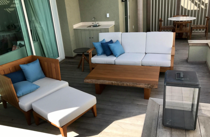 a patio with a white couch and blue pillows