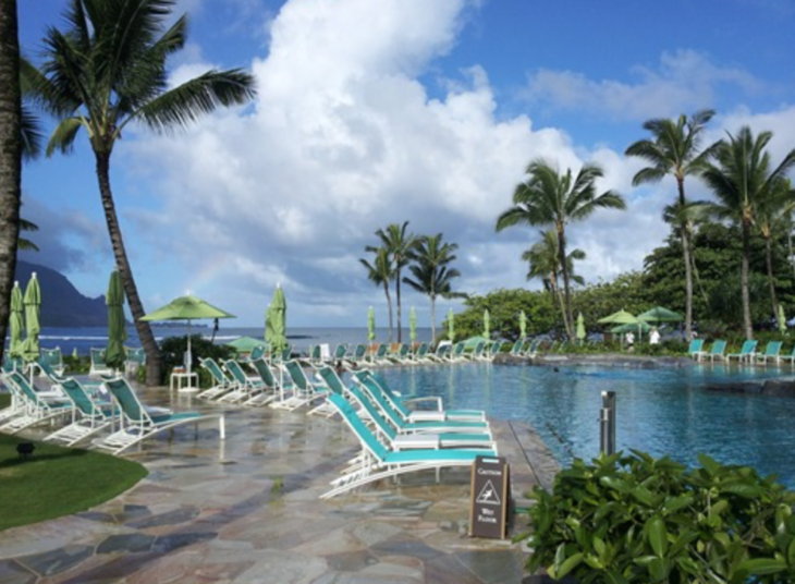 a pool with lounge chairs and palm trees