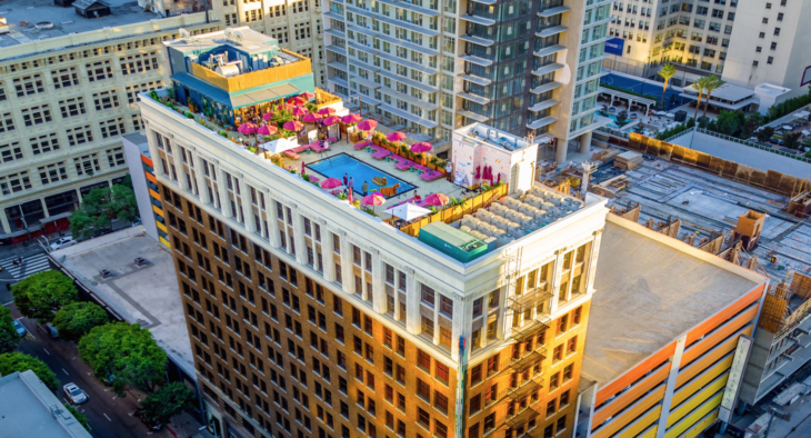 a rooftop of a building with umbrellas and a pool