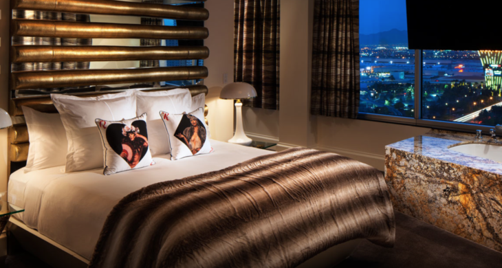 a bed with pillows and a lamp in front of a window