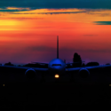 an airplane on the runway at sunset