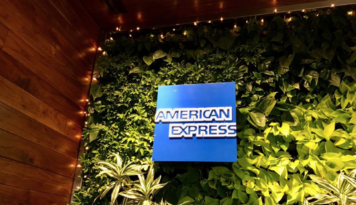a blue sign on a wall of plants