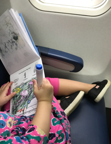 a child sitting on a plane reading a book