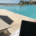 a laptop on a towel next to a pool