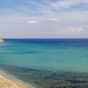 a beach with blue water and sand