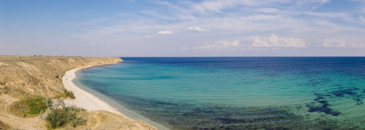 a beach with blue water and sand